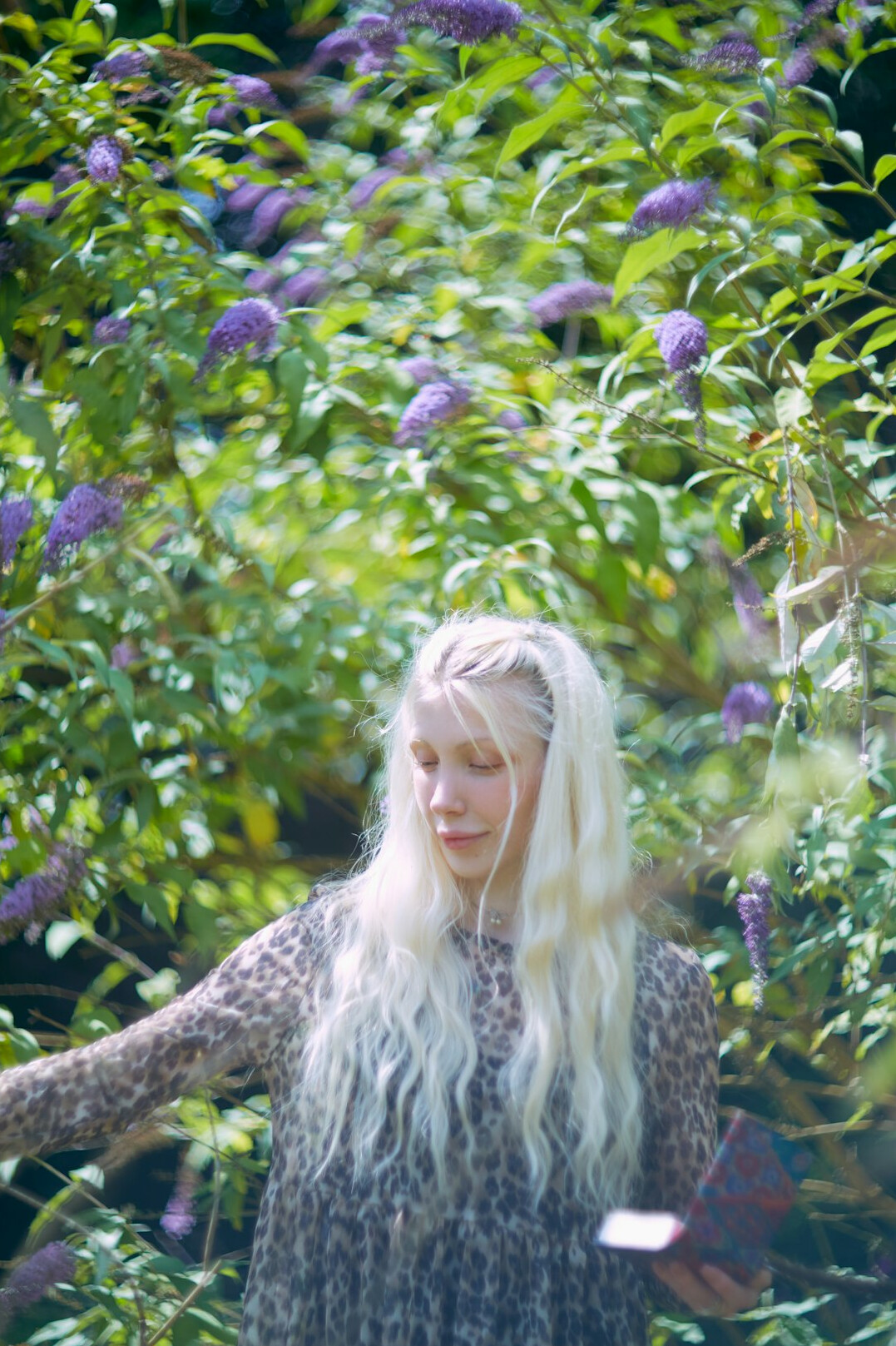 Mature woman with grey hair smiling in a garden