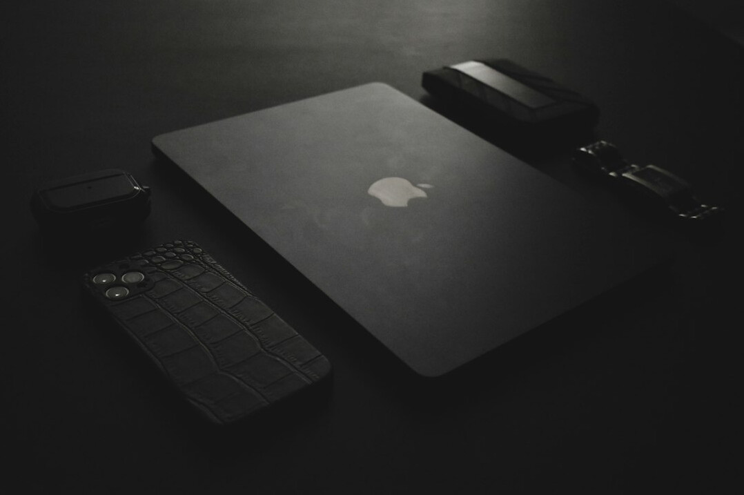 Hands typing on a laptop with a calculator and notebook on the desk